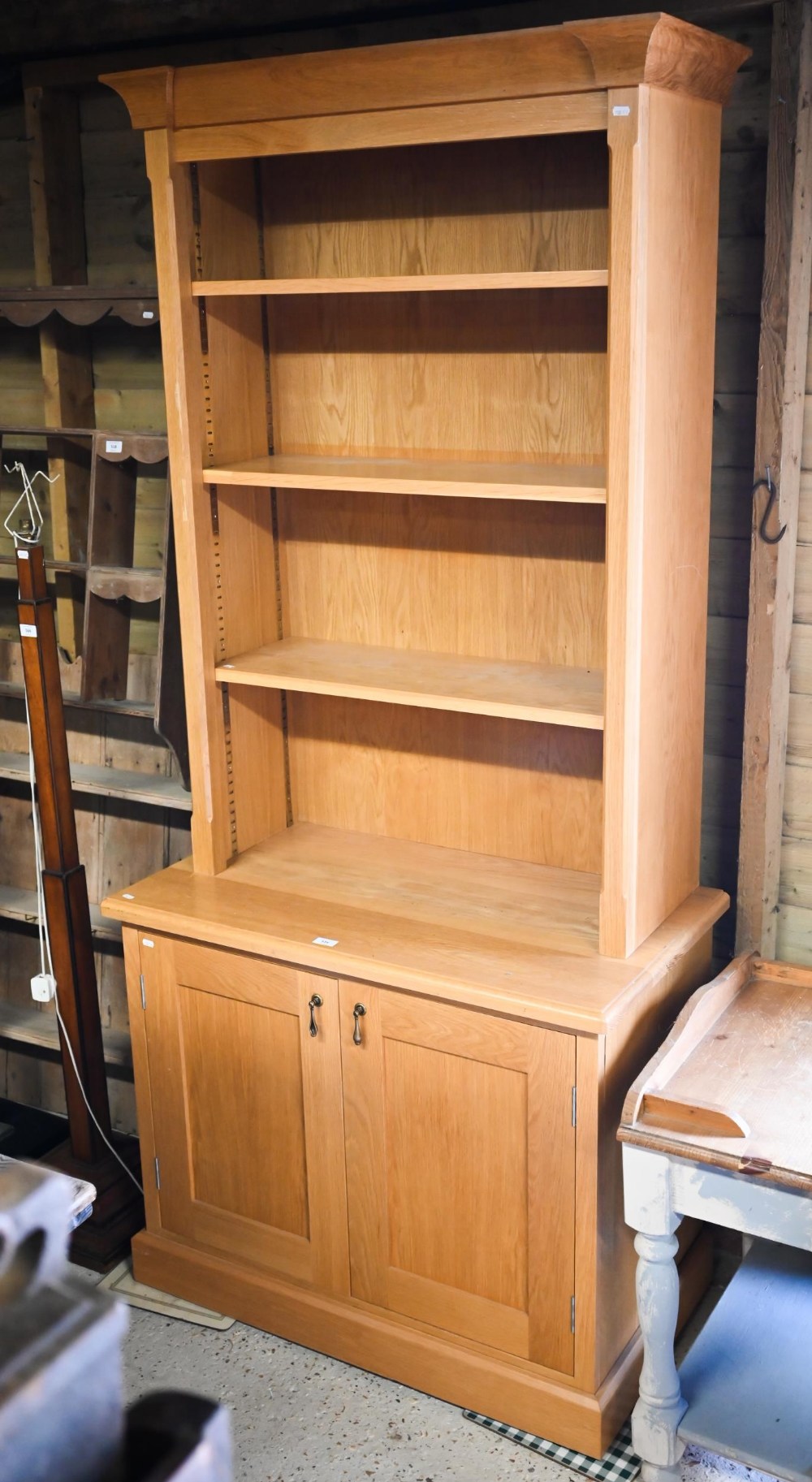 A modern oak cabinet bookcase with three adjustable shelves over base with panelled cupboard, 95 x