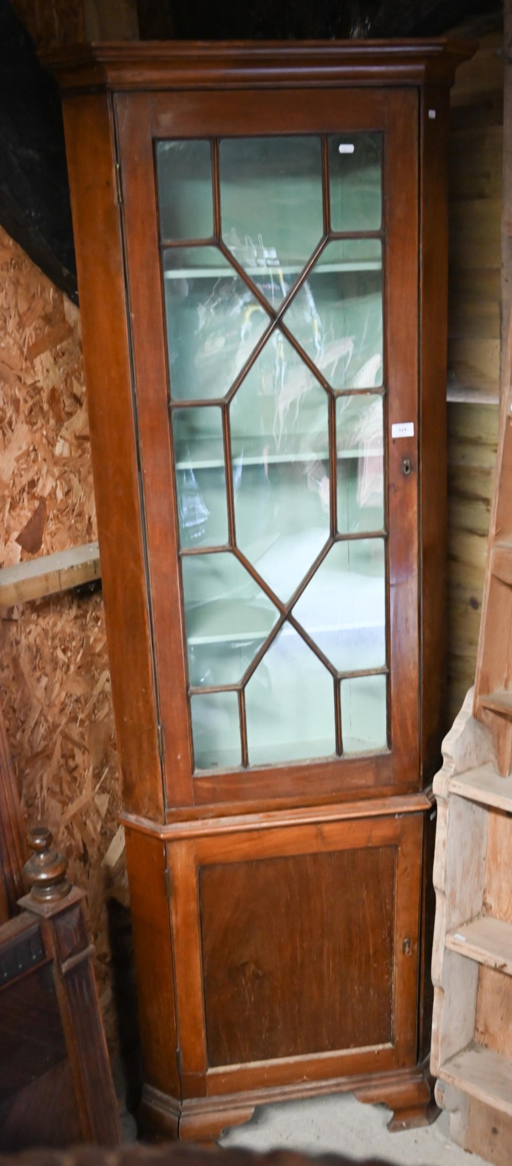 An antique mahogany part glazed floor standing corner cabinet