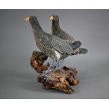 Damian Santamaria, two well executed artisan pottery birds, raised on a weathered wood root-clump