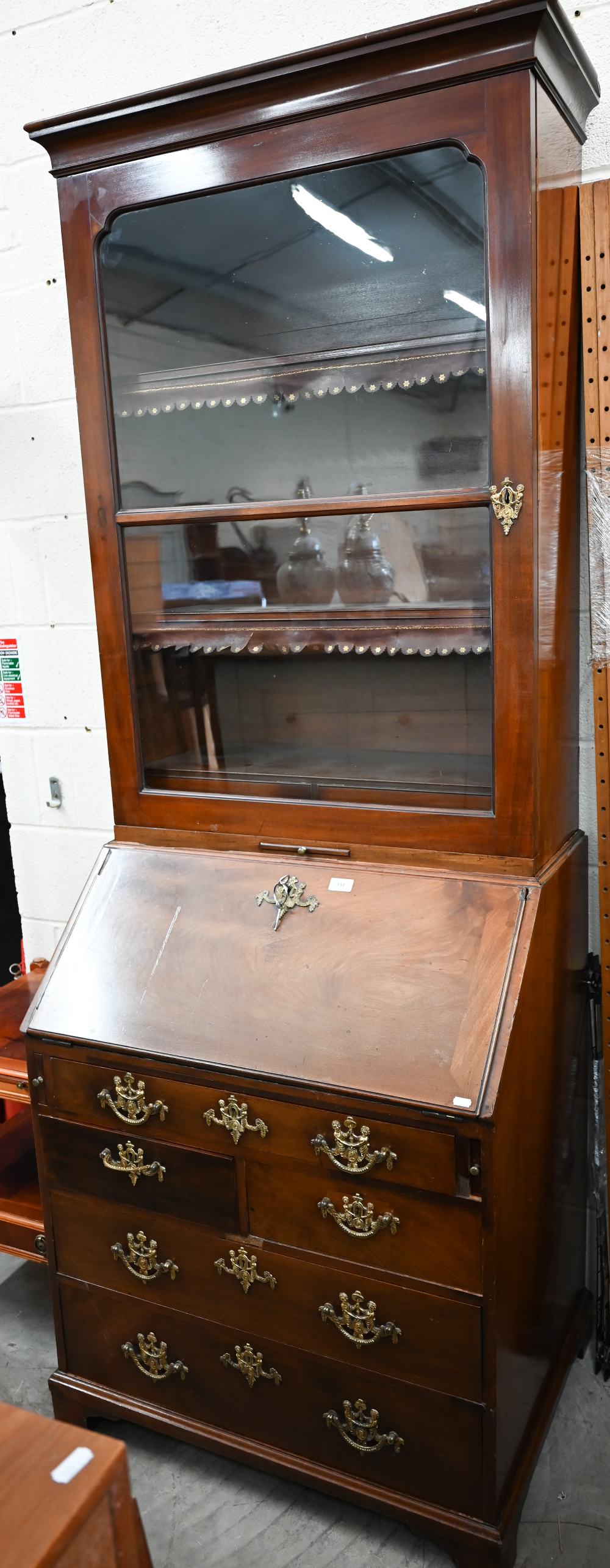 A Georgian mahogany fall front bureau with five drawers and associated glazed bookcase top