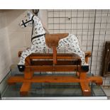 A traditional painted (dappled) wooden children's rocking horse, 115 cm wide x 50 cm deep x 85 cm