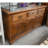 A good quality modern oak sideboard with three drawers over panelled cupboards standing on bracket