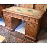 A Victorian oak twin pedestal desk, with nine drawers, raised on plinths and concealed castors -