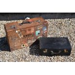A large vintage leather suitcase with various labels including Cunard White Star First Class and