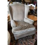A walnut framed Georgian style wingback armchair, brown dralon upholstery
