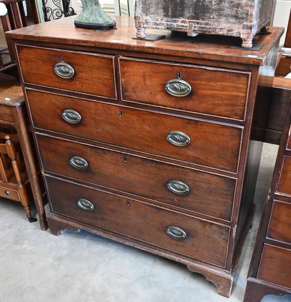 A George III mahogany chest of two short over three long drawers with brass oval handles cast with