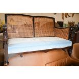 An oak framed bergere two seater sofa wtih caned decoration, 140 cm wide x 80 cm deep x 80 cm high