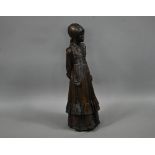 A bronzed fibreglass sculpture of a young woman, standing, in a long dress, 77 cm h