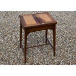 An Edwardian walnut and satin sewing table with hinged twin panelled top enclosing a fitted