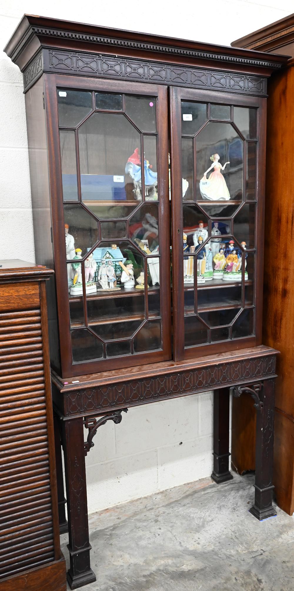 An Edwardian mahogany Chippendale-style bookcase with astragal glazed doors enclosing adjustable