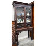 An Edwardian mahogany Chippendale-style bookcase with astragal glazed doors enclosing adjustable