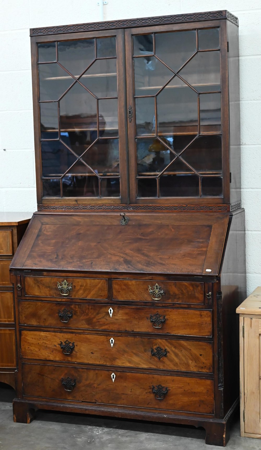 A Georgian mahogany bureau with two short over three long drawers, with associated glazed bookcase