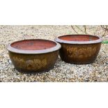 A pair of Chinese style circular salt glazed 'dragon' planters, 44 cm diam x 20 cm high to/w