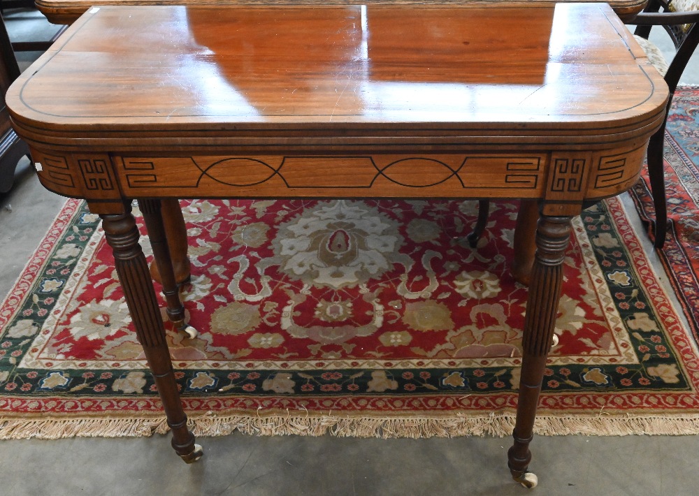 A 19th century mahogany and ebony strung card table with folding baize lined top on turned and