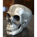 A pewter skull with articulated jaw, 19 cm high