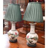 A pair of Chinese ceramic baluster table lamps decorated with peacocks in the famille rose manner,