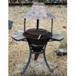 A metal firepit/bbq on stand with tiled surround and metal canopy to/w with a smaller example (2)