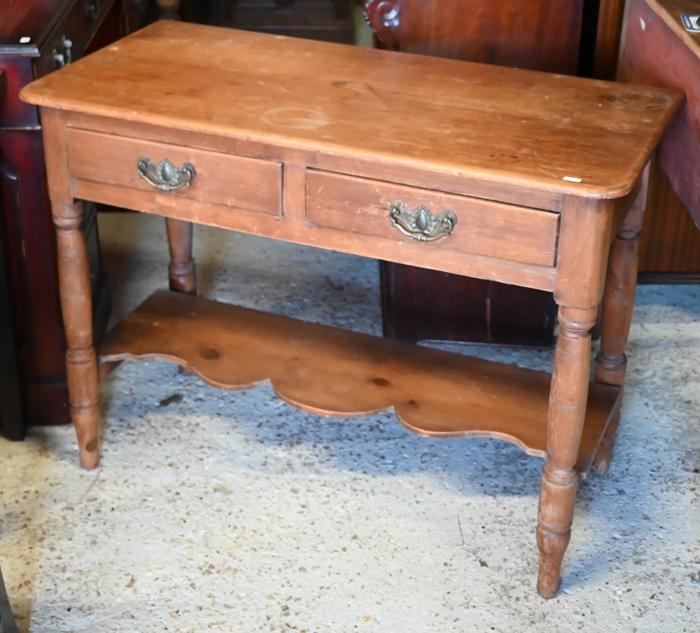 An early 20th century waxed pine hall table with two drawers on turned supports united by undertier,