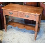 An early 20th century waxed pine hall table with two drawers on turned supports united by undertier,