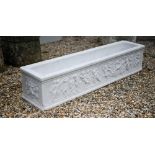 An antique style marble trough planter with relief cut frieze depicting a procession of frolicking