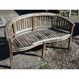 A Tansley curved slatted teak garden bench, 160 cm wide