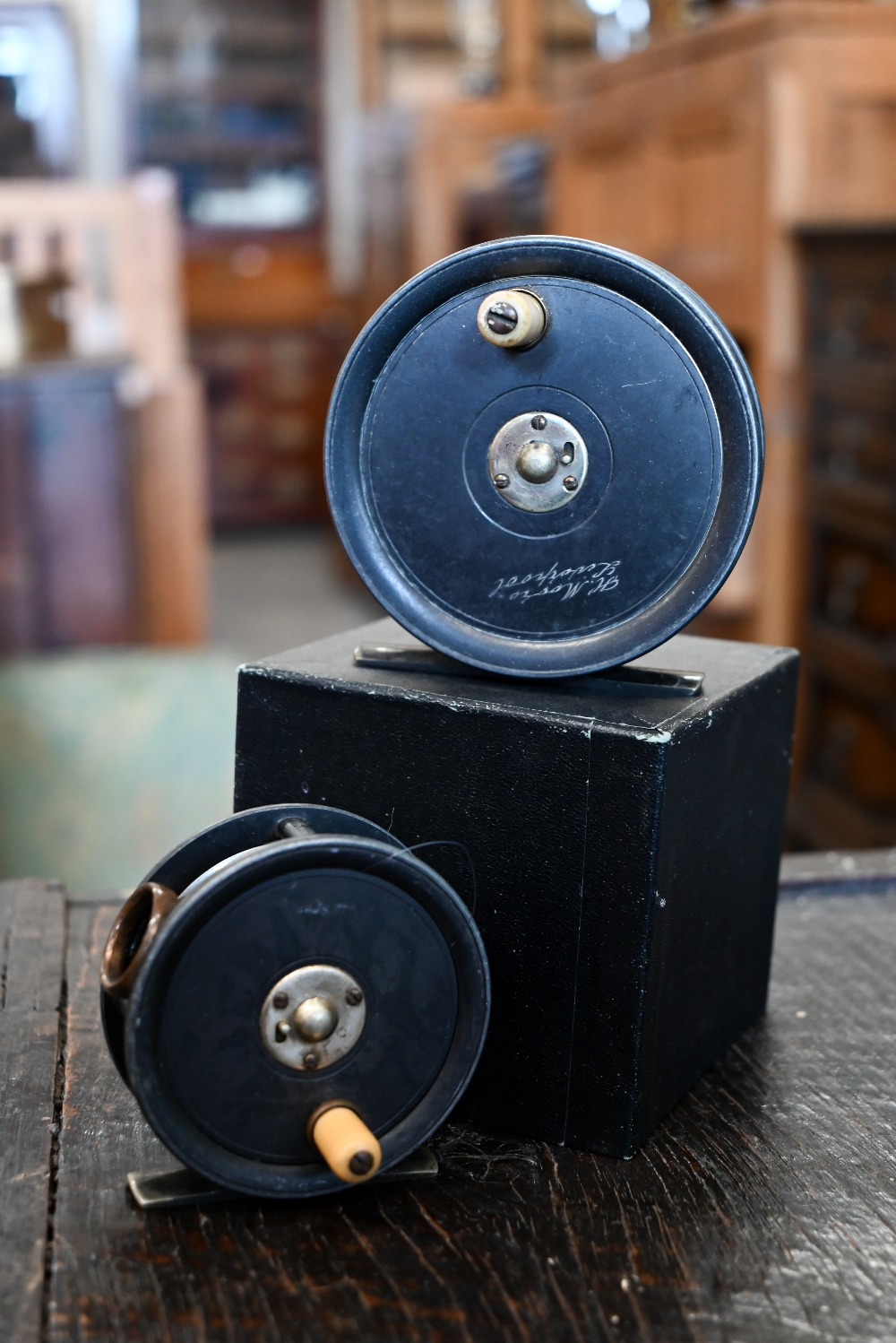 An antique 9cm fly-fishing reel by H Moore, Liverpool to/w a similar 7 cm reel by H Monk,