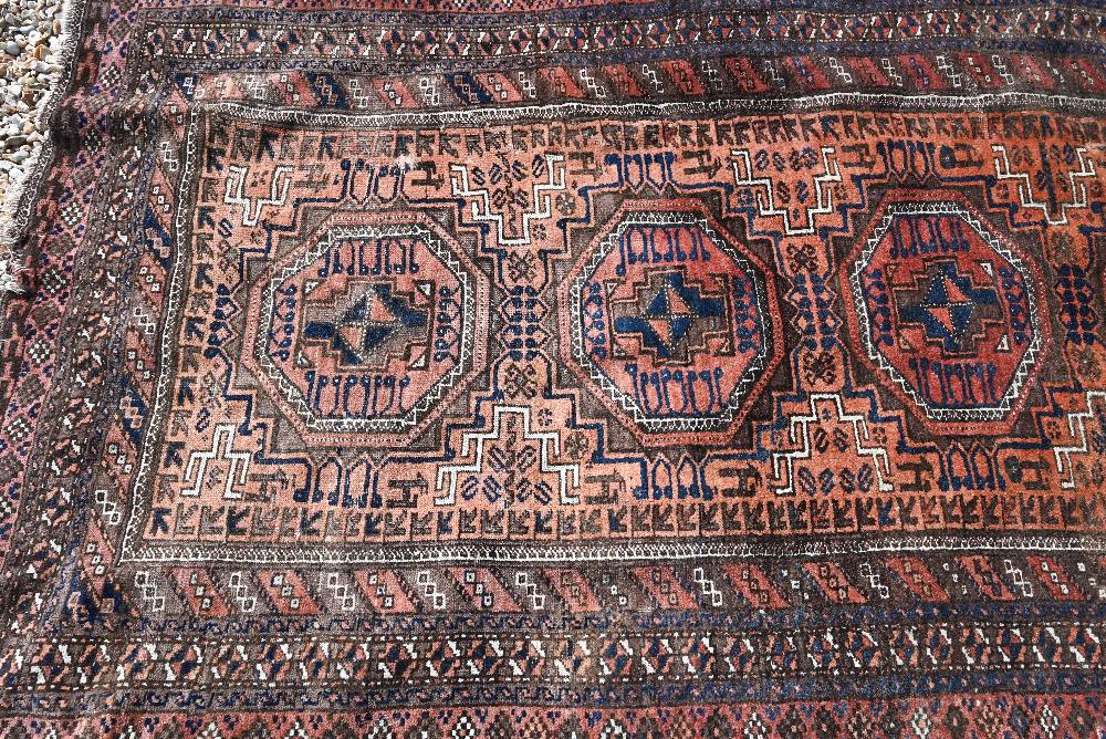 A Persian Balouch rug with four octagonal medallions on brick ground with brown repeating border, - Image 2 of 4