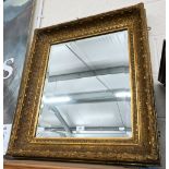 A bevelled rectangular wall mirror in decorative giltwood and gesso frame, 84 x 70 cm