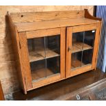 A small oak wall hanging medicine cabinet with leaded glazed doors (glass a/f), 60 cm wide x 20 cm