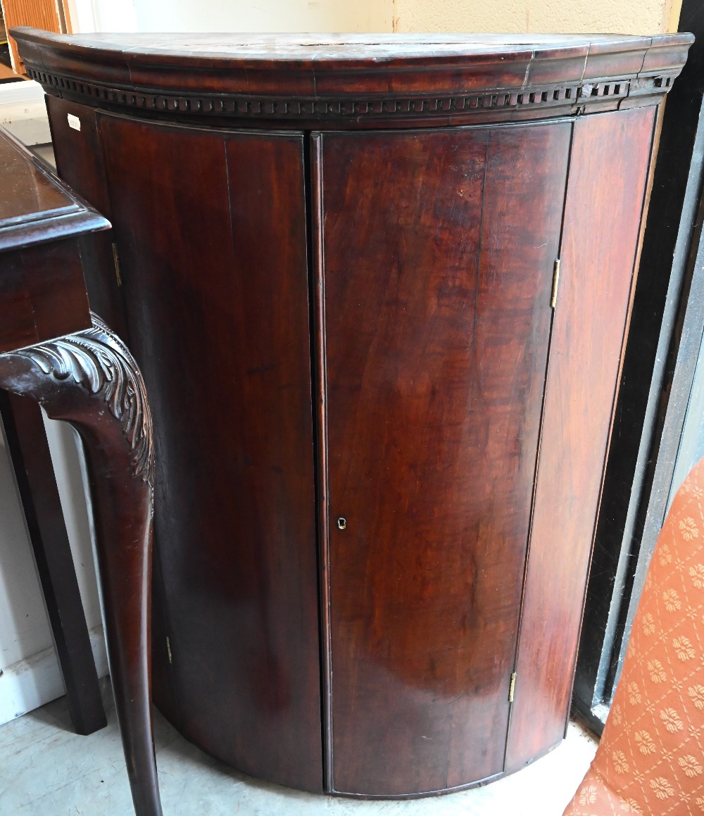 A 19th century mahogany barrel front hanging corner cupboard