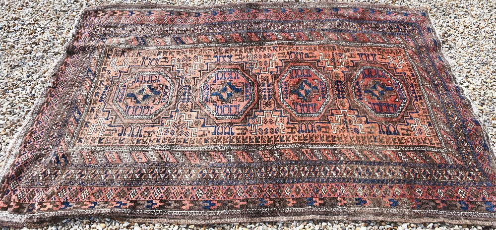 A Persian Balouch rug with four octagonal medallions on brick ground with brown repeating border,