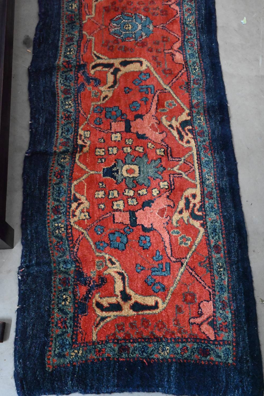 A Persian Bidjar runner with floral design, on red ground with blue borders, 200 x 55 cm