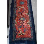 A Persian Bidjar runner with floral design, on red ground with blue borders, 200 x 55 cm