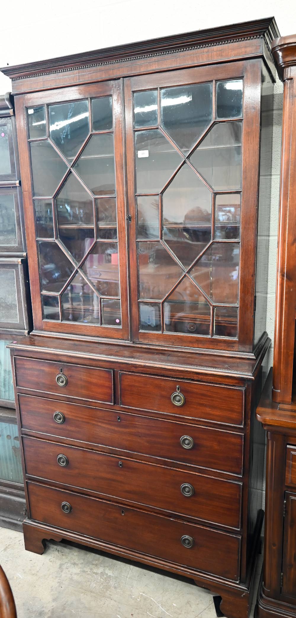 A Georgian mahogany bookcase on chest, the astragal glazed doors over two short and three long