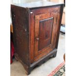 An antique Provincial oak side cabinet on stand with single panelled door enclosing shelves, 60 x 35