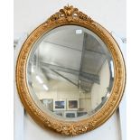 A pair of bevelled oval wall mirrors in foliate gilt frames, 44 cm wide x 54 cm high