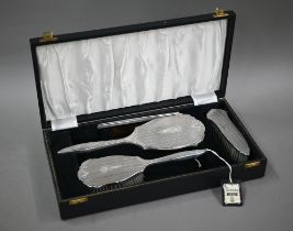 A cased silver four-piece brush set including comb and hand-mirror, Birmingham 1959 (little used)