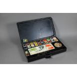 An Edwardian artist's black japanned watercolour box, the hinged lid with gilded coat of arms and