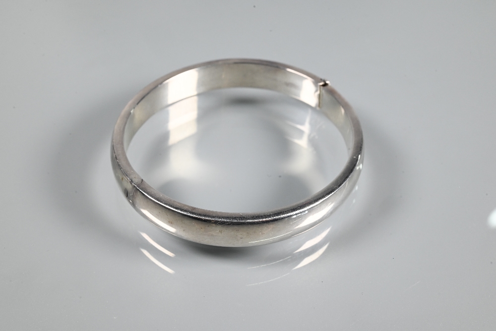 A wide white metal oval half-hinged bangle with engraved floral decoration to front, stamped ' - Image 4 of 5