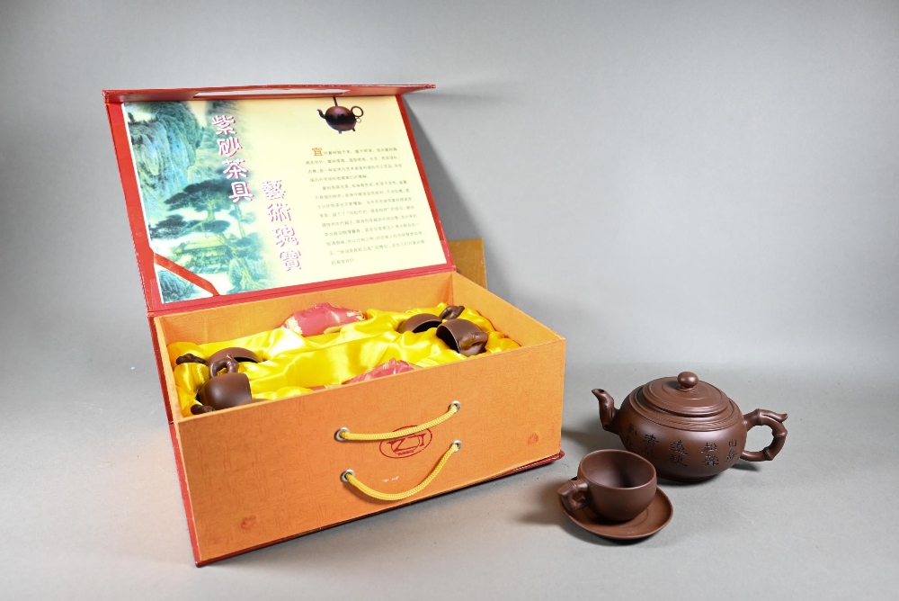 A boxed Chinese Yixing pottery tea set comprising a compressed globular teapot and cover with