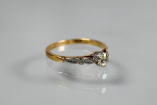 A single stone diamond ring, the claw set diamond of pale yellow hue in 18ct yellow and white gold