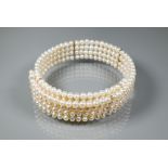 A pearl choker, the four rows of cultured pearls on flexible wire core, approx 15 cm (max)
