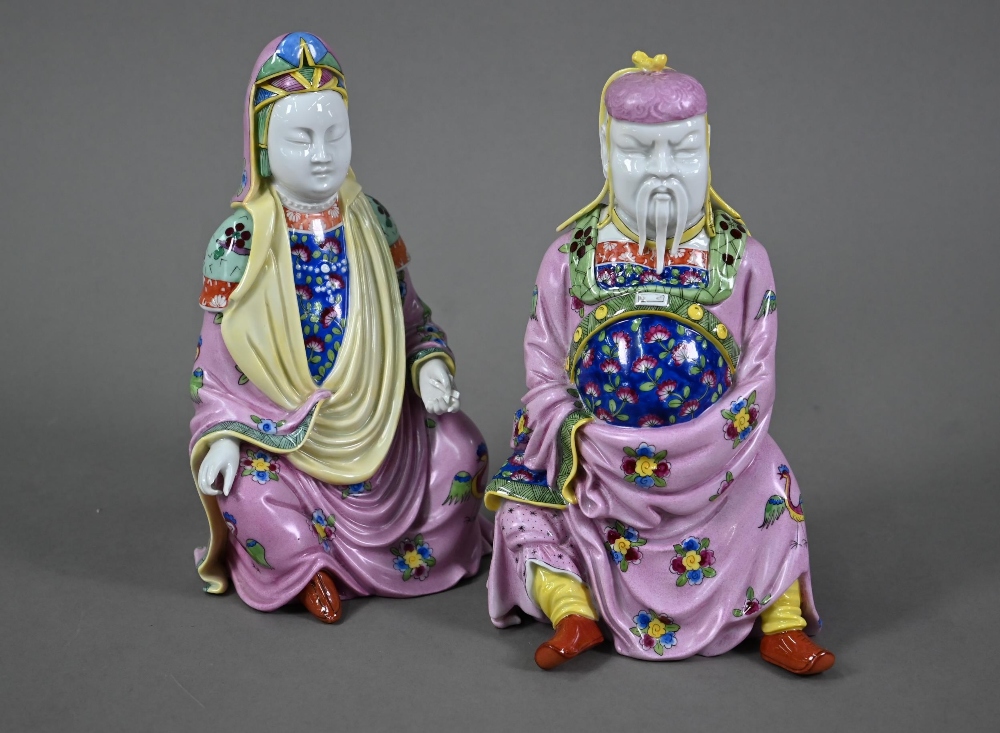 A pair of Dresden figures of a Chinese couple in pink official's robes painted with flowers and