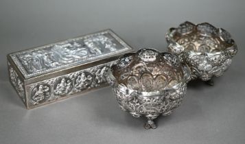 An Indian silver cigarette box, richly embossed and chased with figures, the cover depicting