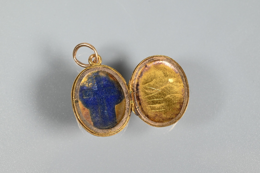 An oval engraved locket with blue enamelled cross to front, unmarked yellow metal, approx 2.9g, - Image 4 of 4