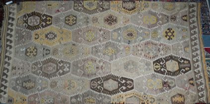 An old Turkish kelim, the soft multi-coloured lozenge design on camel ground, 290 cm x 154 cm