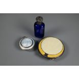 An Art Deco silver and yellow enamel powder compact, Birmingham 1920, 7 cm diam; a locket silver and