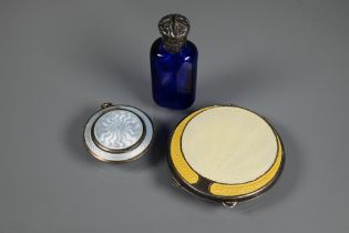 An Art Deco silver and yellow enamel powder compact, Birmingham 1920, 7 cm diam; a locket silver and