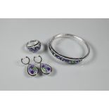 A suite comprising half-hinged bangle, bombe-style ring and pendant drop earrings, each set with