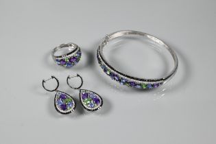 A suite comprising half-hinged bangle, bombe-style ring and pendant drop earrings, each set with